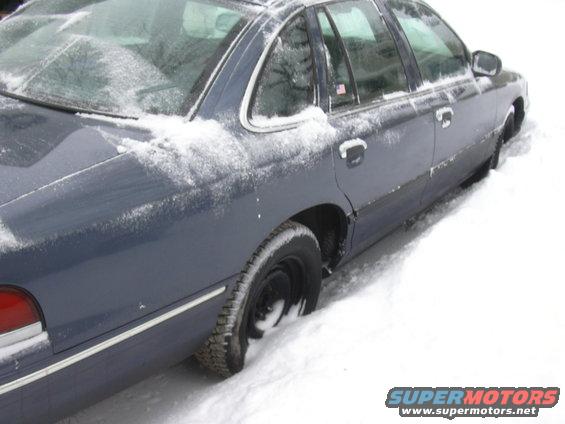 Dark blue 1996 Ford Crown Victoria side view stuck in snow
