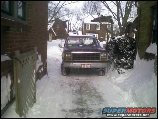 Maroon Ford F-250 truck parked in snow, front view. Grille and headlights visible
