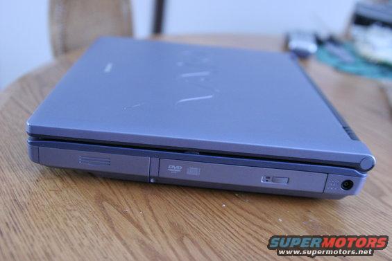 Closed blue laptop with DVD drive on a wooden table