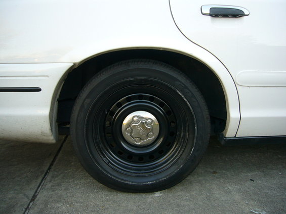 White Ford Crown Victoria rear wheel and part of the rear door
