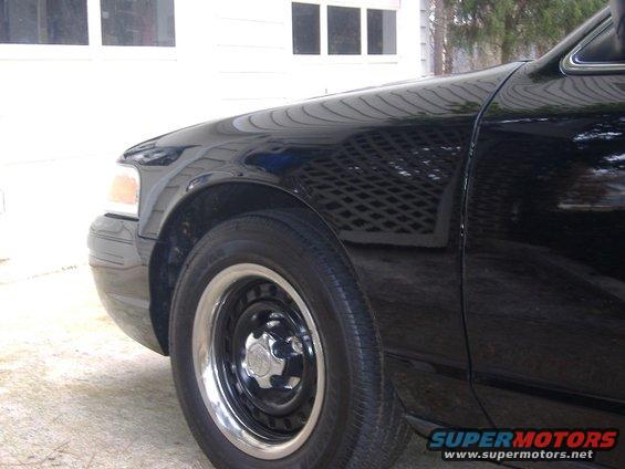 Front fender and wheel of a black 2001 Ford Crown Victoria