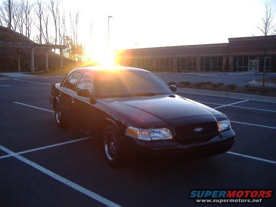 Black 2001 Ford Crown Victoria parked in a lot at sunset