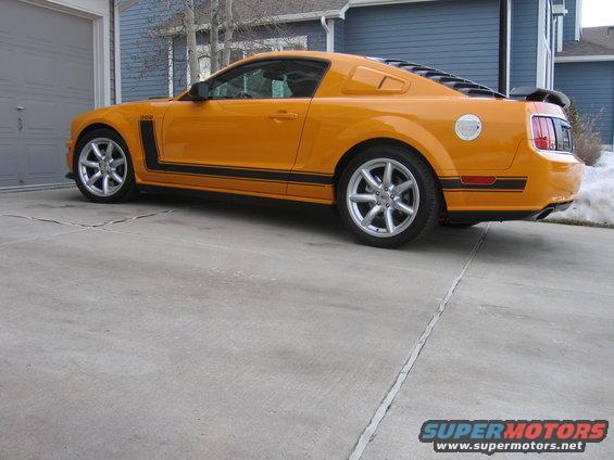 Orange 2007 Saleen S-302 Mustang with black racing stripes parked on a concrete driveway