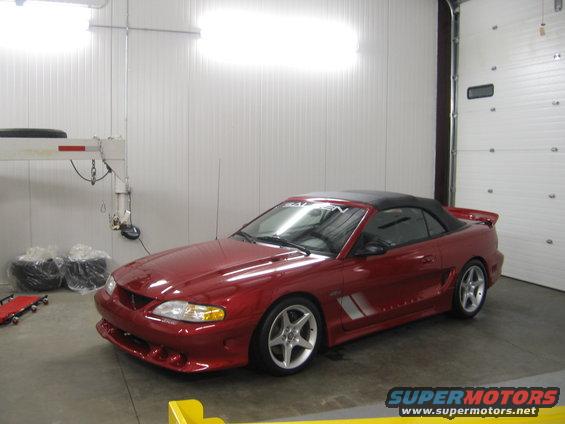 Red convertible Mustang in garage, has Saleen windshield banner