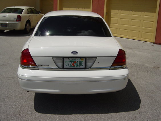 2000 Ford Crown Victoria rear view, Florida license plate S72 1HE. Another white sedan is parked to the left