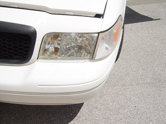White 2000 Ford Crown Victoria front corner with honeycomb grille and clear headlight
