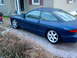 1994 Ford Probe - A blue 1994 Ford Probe GT is parked on a gravel driveway next to a house.