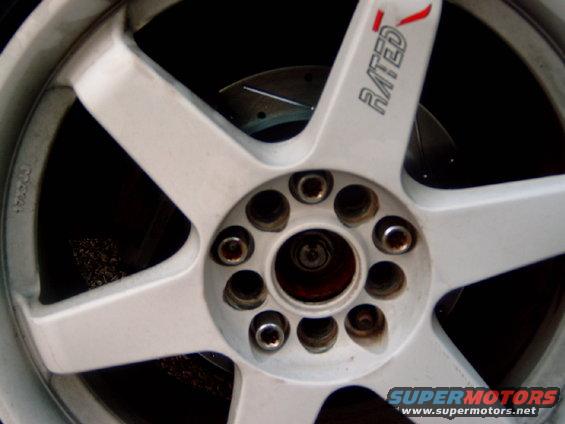 White five-spoke wheel with 'RATED' text and visible brake rotor