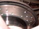 1994 Ford Probe - Close-up of a slotted and drilled brake rotor, the Supermotors logo at the bottom right.