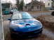 1994 Ford Probe - A blue Ford Probe with distinctive hood scoops is parked in a residential driveway.
