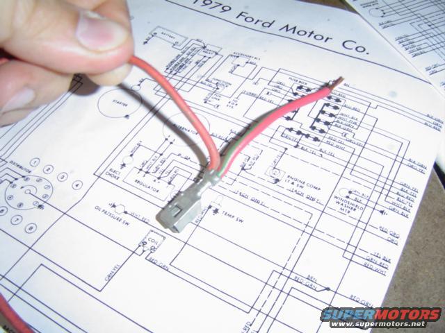 Wiring diagram for a 1979 Ford Motor Co. vehicle with a hand holding a red wire