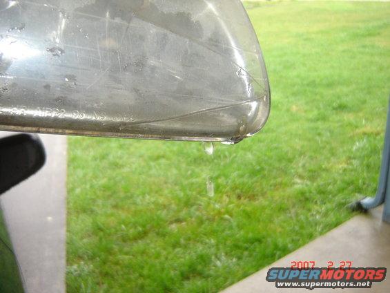 Headlight with visible cracks and water dripping, showing text 'MPP2 96 AS'