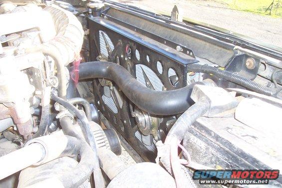 Radiator and fan assembly with hoses and engine components visible