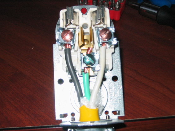 Electrical plug wiring with black, white, and green wires connected to terminals