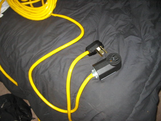 Yellow extension cord with a black plug and a black adapter