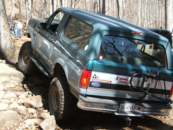 1996 Ford Bronco navigating a rocky trail, with another vehicle visible in the background