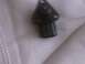 1995 Ford Probe - Unidentified dark metal automotive part with mounting holes, placed on a white surface.