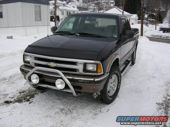 Black Chevrolet S-10 pickup truck with chrome bull bar and fog lights parked in snow