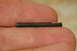 1993 Ford Bronco - A small metal pin is held between fingers, showing its cylindrical shape and metallic surface.