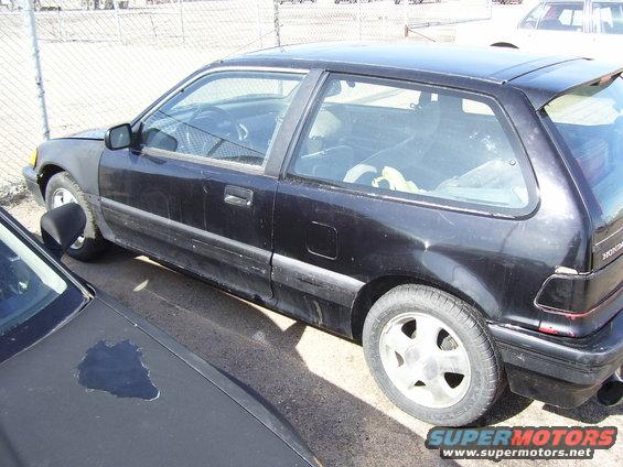 Black hatchback parked next to another car. Front fender is a different color