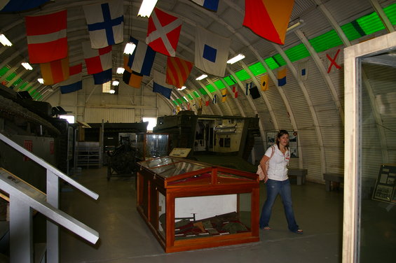 Museum interior with nautical flags and military vehicles