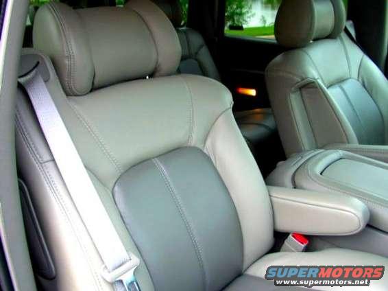 Interior view of light-colored leather seats with gray inserts and a seatbelt