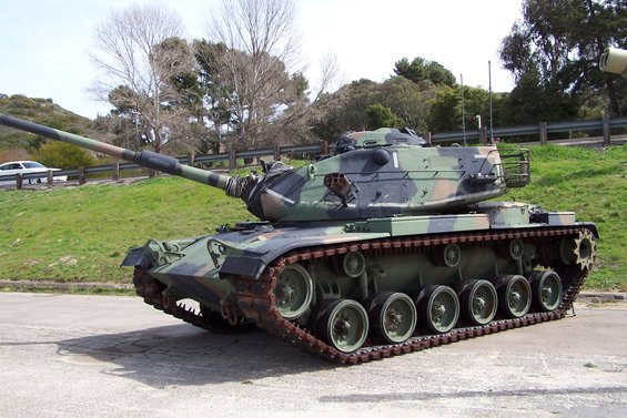 Military tank with camouflage paint and tracks