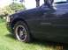 1998 Ford Crown Victoria - A dark 1998 Ford Crown Victoria Interceptor is shown from the front quarter angle, parked on a grassy area.