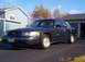 1998 Ford Crown Victoria - A dark green 1998 Ford Crown Victoria sedan is parked in front of a garage.