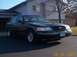 1998 Ford Crown Victoria - A black 1998 Ford Crown Victoria is parked in front of a house on a sunny day.