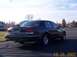 1998 Ford Crown Victoria - A dark 1998 Ford Crown Victoria sedan is viewed from the rear 3/4 angle on a paved surface.