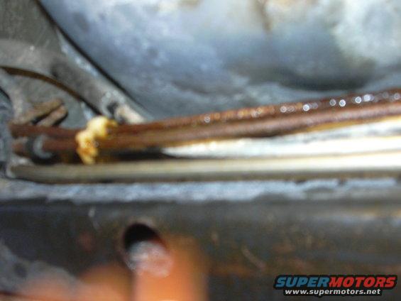 Close-up of rusty brake lines with some yellow residue