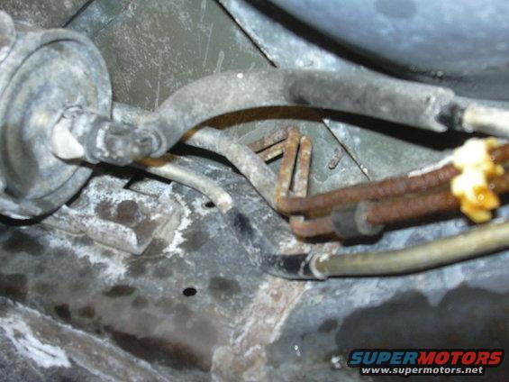 Fuel filter and lines, some rusty, with yellow sealant
