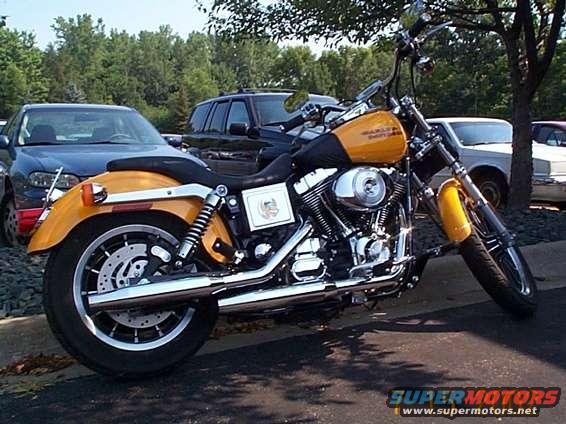 Yellow Harley-Davidson motorcycle parked next to cars
