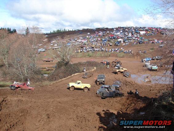 Mud bog scene with multiple off-road trucks and SUVs stuck in mud