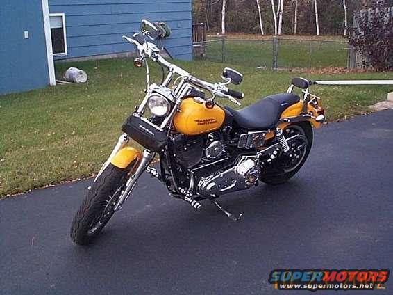 Yellow Harley-Davidson motorcycle parked on asphalt driveway
