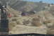 1995 Ford Bronco - Multiple off-road vehicles navigate a dusty, arid terrain with hills in the background.