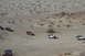 1995 Ford Bronco - Multiple Jeeps traverse a desert landscape, kicking up dust on the sandy trails.