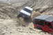 1995 Ford Bronco - Two off-road vehicles tackle a challenging dirt path in a desert landscape.