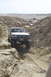 1995 Ford Bronco - Several vehicles navigate a steep, sandy canyon trail under a clear sky.