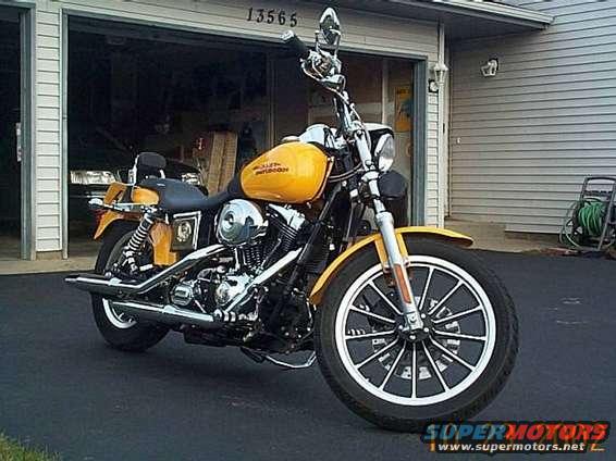 Yellow Harley-Davidson motorcycle parked in front of a garage