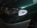 1997 Dodge Grand Caravan - Headlight assembly detail on a dark green vehicle.