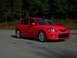2007 Mazda 3 - Red 2007 Mazda 3 hatchback parked outdoors.