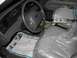 2003 Ford Crown Victoria - The interior of a 2003 Ford Crown Victoria is visible, with seats covered in protective plastic and newspapers on the floor.