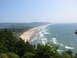 1979 Ford Bronco - A scenic view of a coastline with a beach and ocean waves under a clear sky.