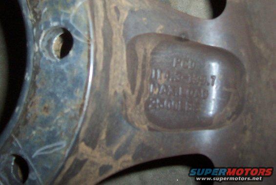 Close-up of a rusty metal wheel rim with stamped text indicating PCD 110.5-139.7 and MAX LOAD 2500 LBS