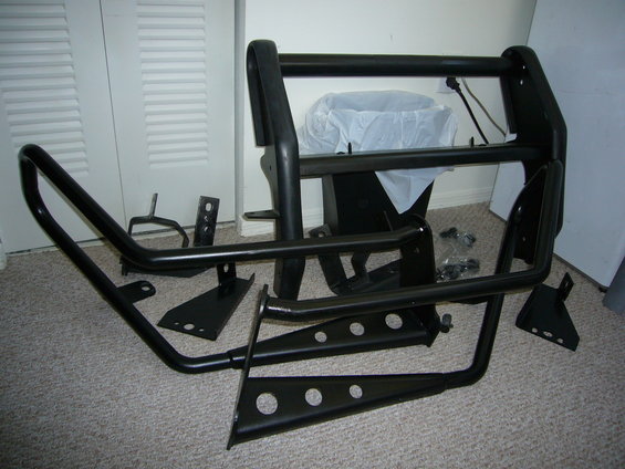 Black bull bar and mounting brackets laid out on carpet