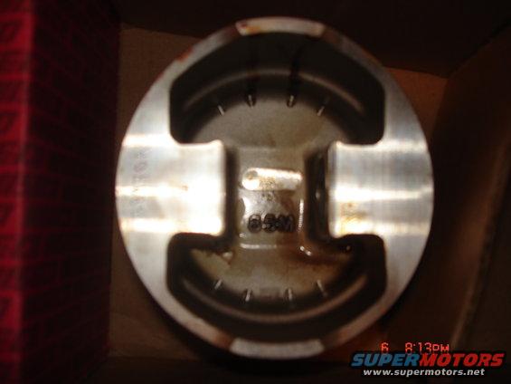 Close-up of an engine piston with markings '65M' and '707' visible