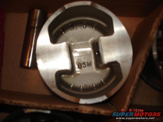 Piston with '85M' marking inside a cardboard box
