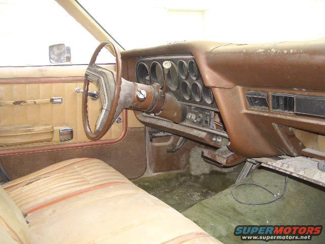 car interior with brown dashboard, steering wheel, and tan seats